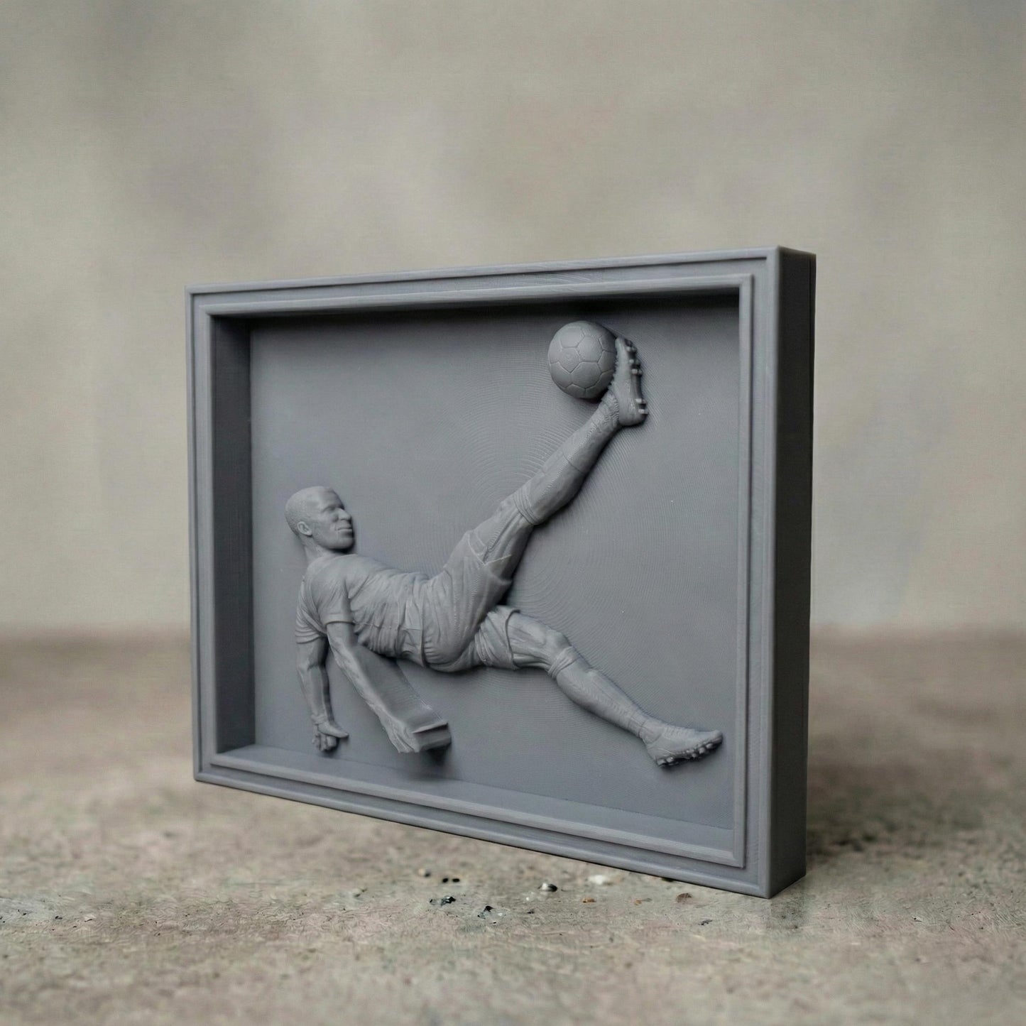 Highly detailed 3D bas-relief of a soccer player performing an overhead bicycle kick, carved in a realistic wood style. The athletic figure is captured mid-air with extended leg striking a football, showcasing dynamic motion, muscle definition, and flowing sportswear. Ideal for CNC carving, 3D printing, and wall-mounted sports decor, symbolizing passion, strength, and competitive spirit in football-inspired art.