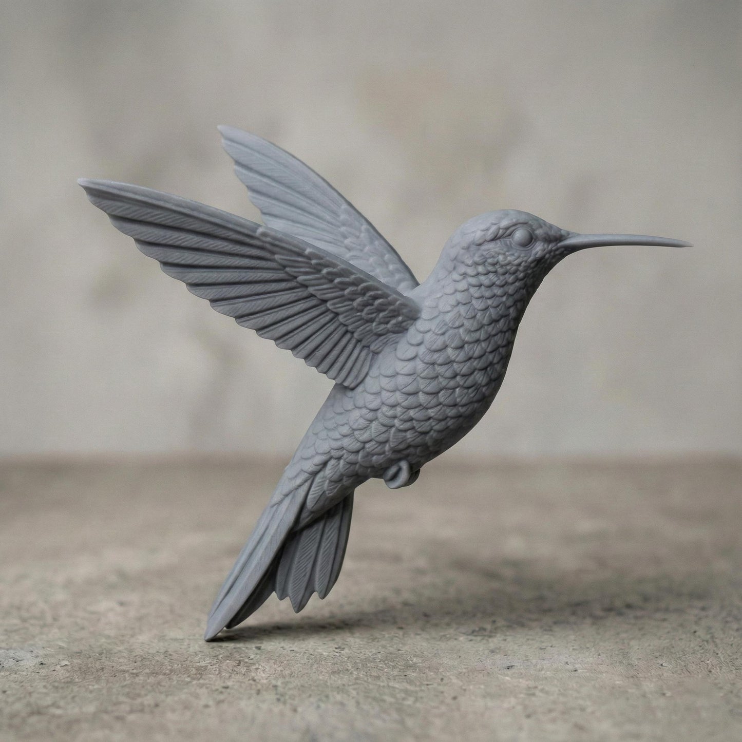 Realistic flying hummingbird 3D sculpture with wings fully extended and detailed layered feathers, captured mid-air in a natural hovering pose. The model features a long pointed beak, textured plumage, and smooth flowing contours suitable for freestanding display. Designed for CNC carving or 3D printing, this wildlife-inspired sculpture conveys motion, elegance, and nature realism.