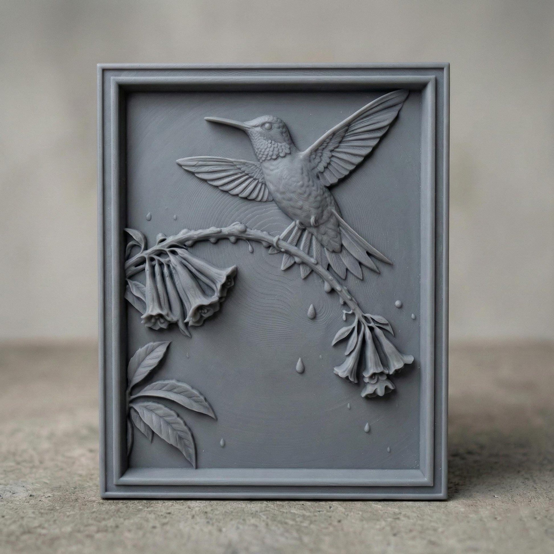 Elegant hummingbird bas relief STL depicting a hummingbird in flight feeding from cascading bell-shaped flowers, carved within a refined rectangular frame. The design features flowing leaves, delicate floral textures, and detailed feathers set against a smooth wood-grain background. Ideal for CNC wood carving, 3D printing, or framed wall art panels inspired by botanical and wildlife themes.