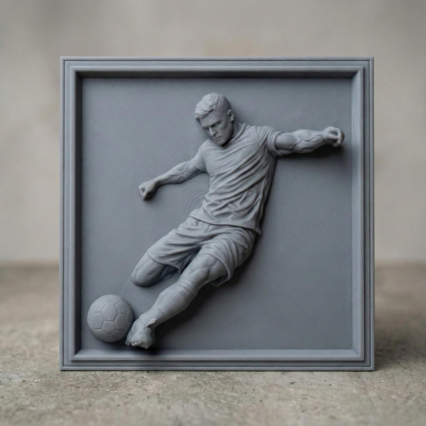 Detailed bas-relief sculpture of a soccer player captured mid-kick, shown as a realistic carved wooden relief with dynamic motion, muscular anatomy, flowing clothing folds, and a soccer ball at the foot. The design features deep relief depth, clean contours, and smooth transitions ideal for CNC carving, 3D printing, or router engraving as decorative sports wall art.