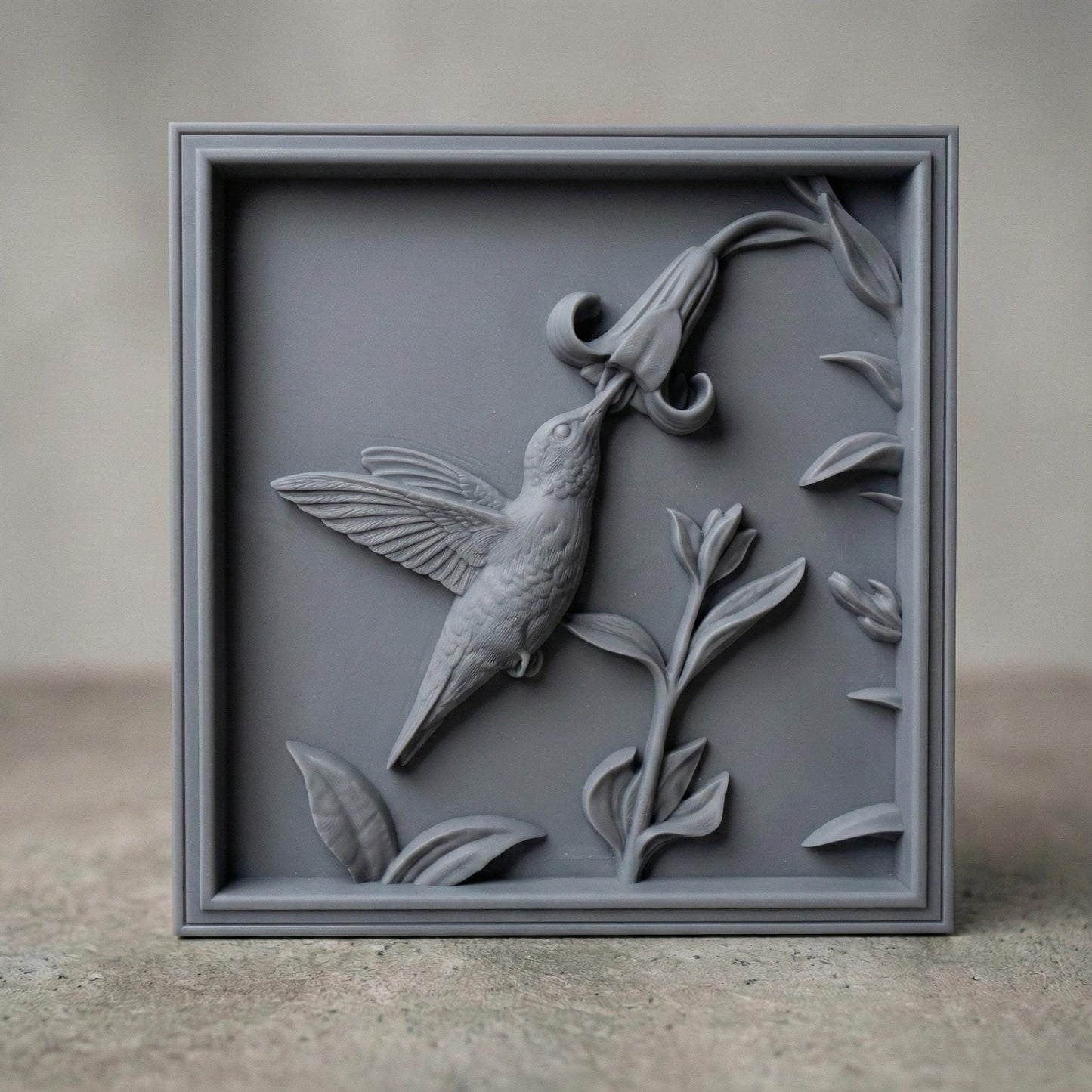 Elegant hummingbird bas relief STL depicting a hummingbird in flight feeding from cascading bell-shaped flowers, carved within a refined rectangular frame. The design features flowing leaves, delicate floral textures, and detailed feathers set against a smooth wood-grain background. Ideal for CNC wood carving, 3D printing, or framed wall art panels inspired by botanical and wildlife themes.