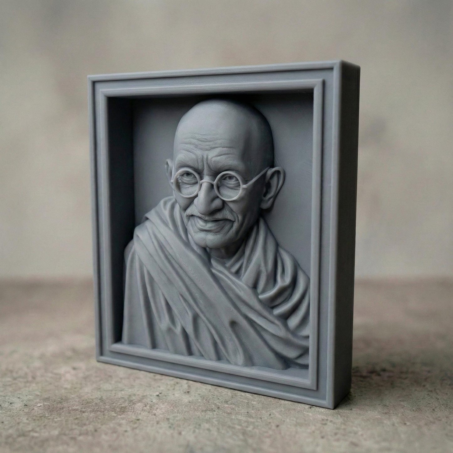 Highly detailed wooden bas-relief sculpture of Mahatma Gandhi featuring his serene expression, round glasses, bald head, and draped shawl. The portrait is carved in rich wood grain texture, highlighting facial wrinkles and soft folds of fabric. Displayed as both a freestanding bust and framed wall relief, symbolizing peace, wisdom, humility, and spiritual leadership.