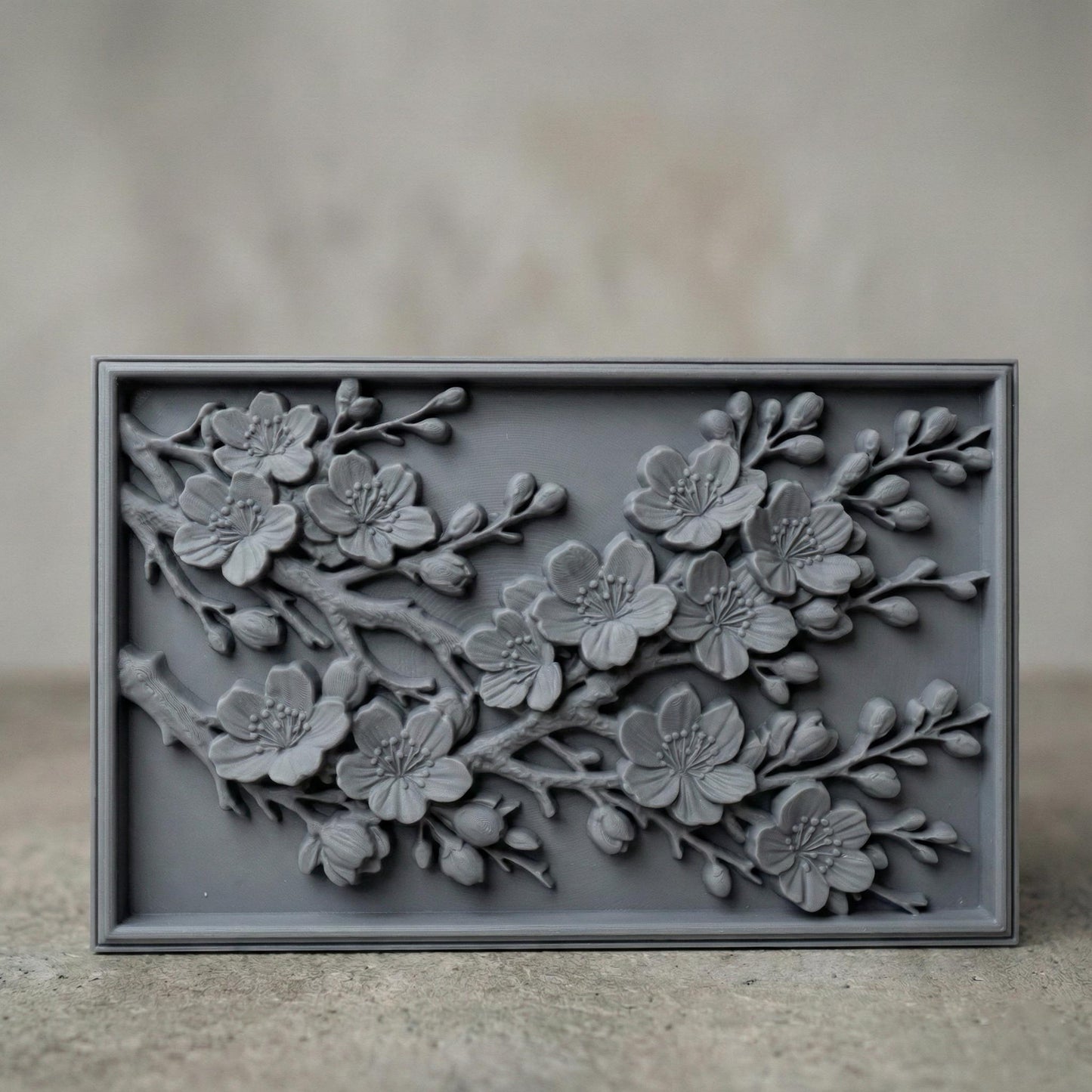 Rectangular bas-relief panel featuring detailed cherry blossom branches in full bloom. Delicate five-petal flowers with textured stamens and closed buds extend diagonally across the composition. Layered petals and organic wood grain texture enhance depth and realism. Framed in a clean border, this floral design symbolizes renewal, spring, and elegance, ideal for CNC carving, 3D printing, and decorative wall panels.