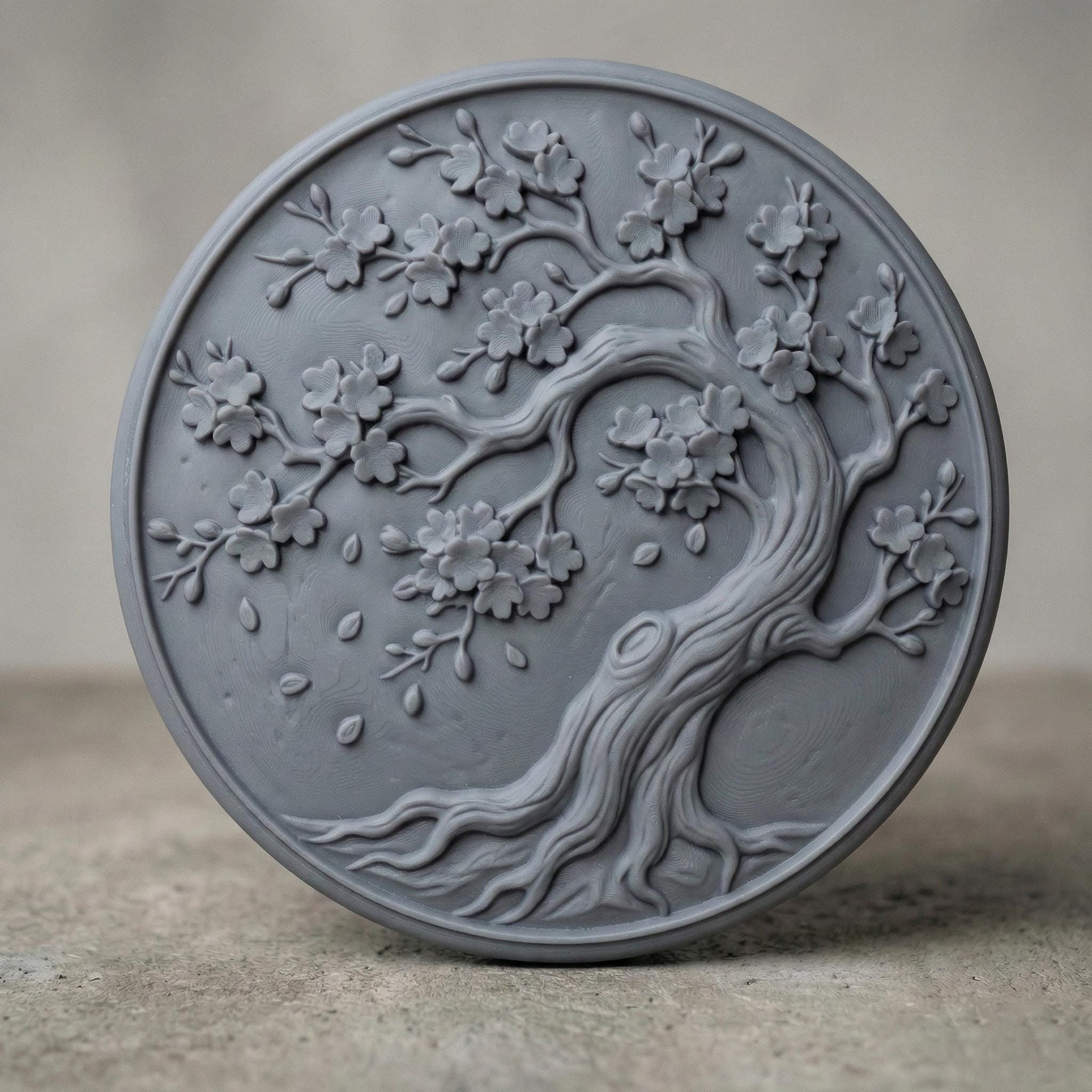 Round bas-relief panel featuring an elegant cherry blossom tree with flowing curved trunk, detailed branches, and blooming flowers. Delicate petals appear gently falling around the tree, creating a peaceful and natural composition. The circular frame enhances balance and harmony, making it ideal as decorative wall art for CNC carving or 3D printing with rich organic texture and depth.