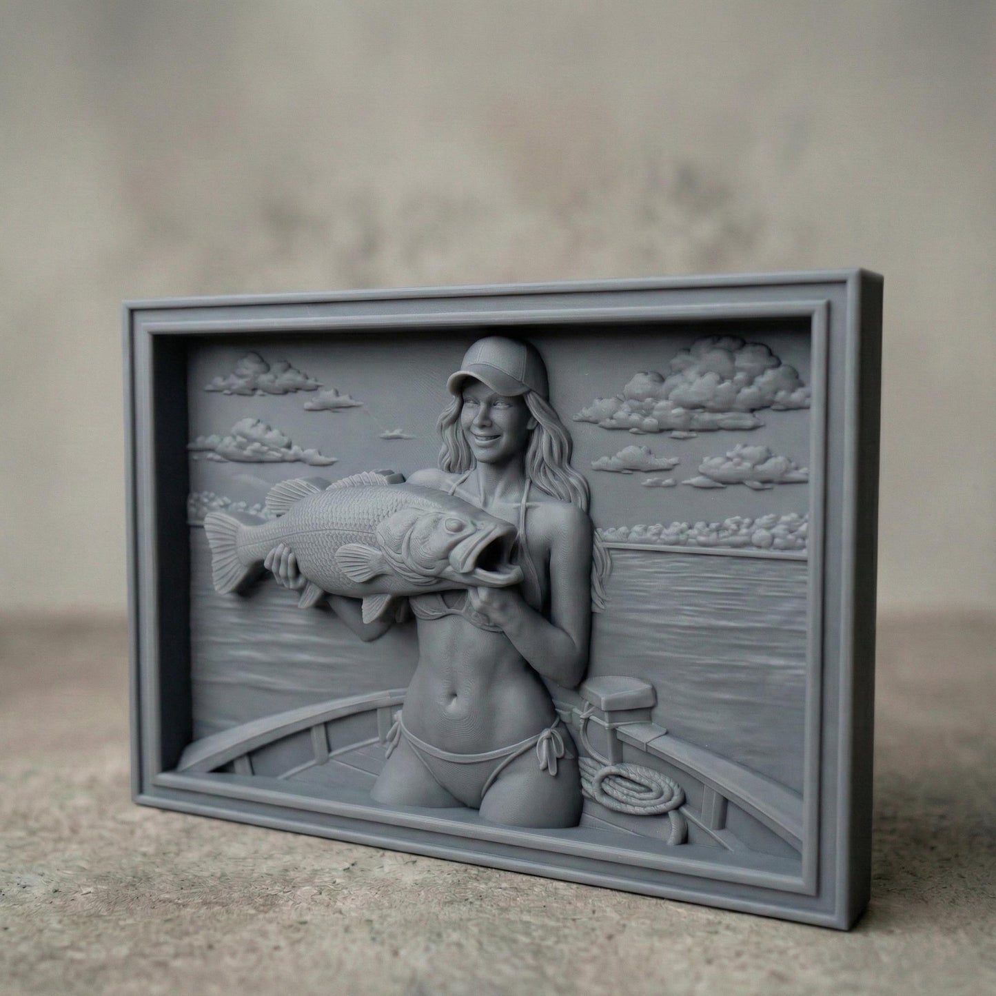 Detailed bas-relief carving of a smiling female angler holding a large bass fish while standing on a boat. The scene features calm lake water, carved clouds in the sky, and realistic wood grain texture. The rectangular framed panel highlights fine details in the fish scales, facial expression, and boat elements, designed for CNC carving or 3D printing as rustic fishing wall decor.