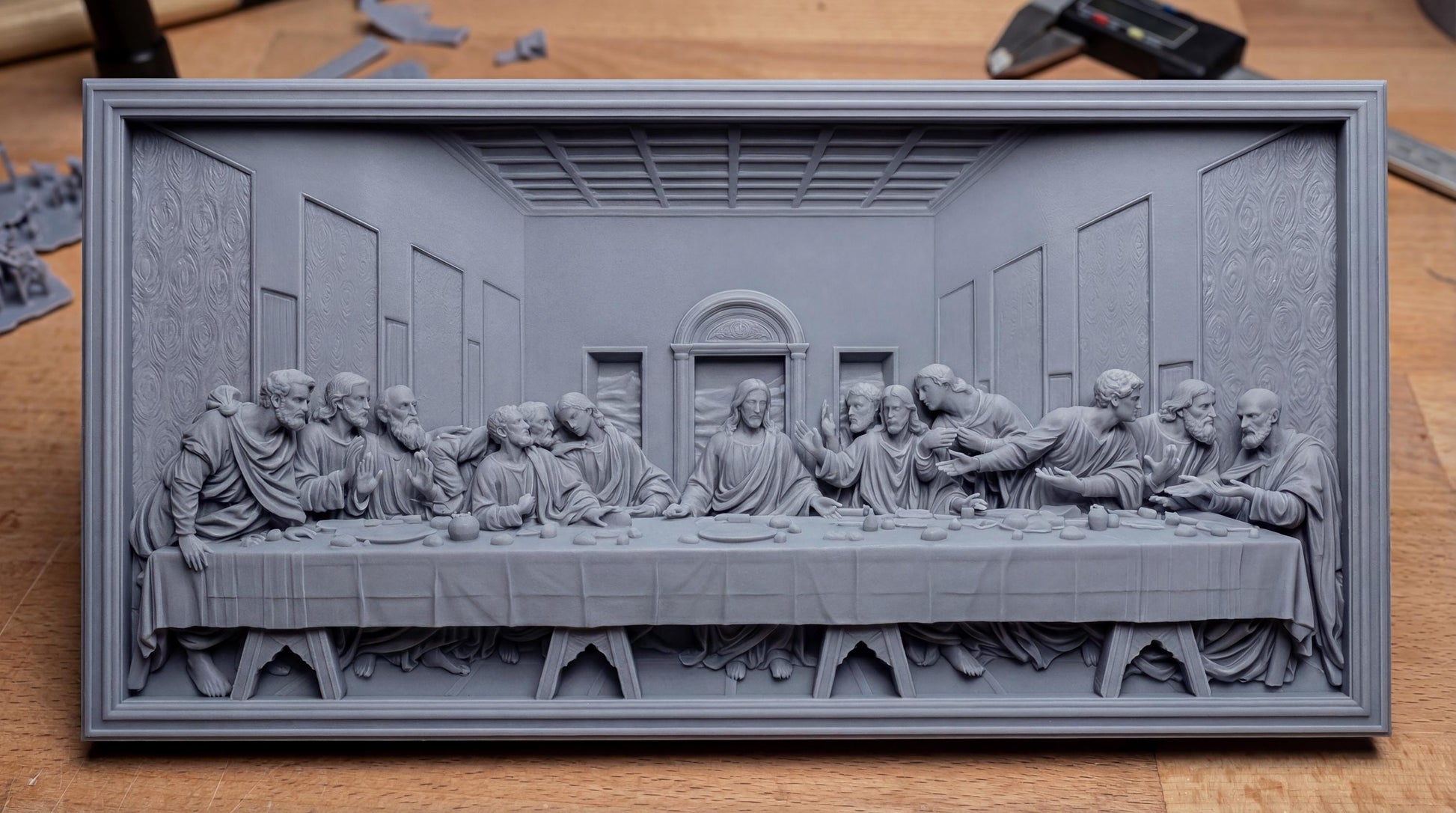 Highly detailed bas-relief depiction of the Last Supper featuring Jesus Christ seated at the center with the twelve apostles gathered around a long dining table inside a classical interior setting. The scene shows expressive gestures, flowing robes, textured walls, and architectural depth. Designed as a framed rectangular relief panel suitable for CNC carving, 3D printing, and church or home devotional wall décor.