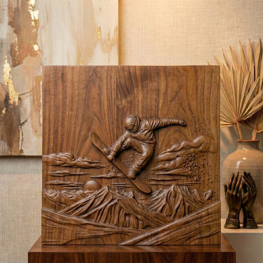 High-relief carving of a snowboarder mid-air performing a jump above rugged mountain peaks at sunset. The rider wears a helmet and winter gear, surrounded by swirling clouds and scattered snow particles. The background features layered mountain ranges and a low sun on the horizon, creating depth and motion. Designed as a detailed bas-relief panel suitable for CNC carving or 3D printing, capturing dynamic winter sports energy and alpine adventure.