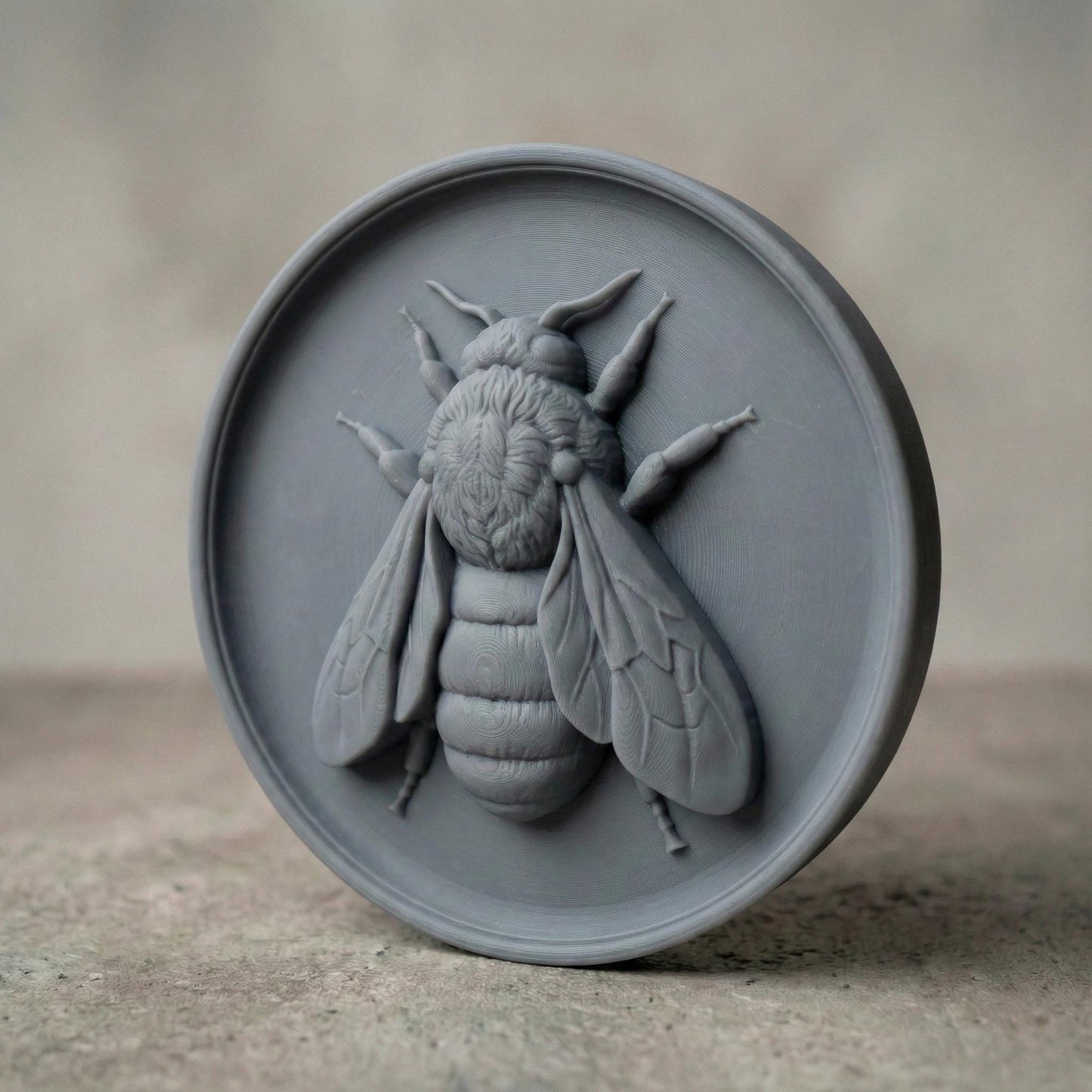 Round bas-relief featuring a realistic honey bee with detailed wings, textured thorax, and segmented abdomen carved in deep relief. The bee is centered on a circular wood panel with natural grain patterns, symbolizing spring renewal, pollination, and growth. Strong shadow lines and layered carving add depth and dimension, making this design ideal for CNC carving, 3D printing, and spring farmhouse wall decor.