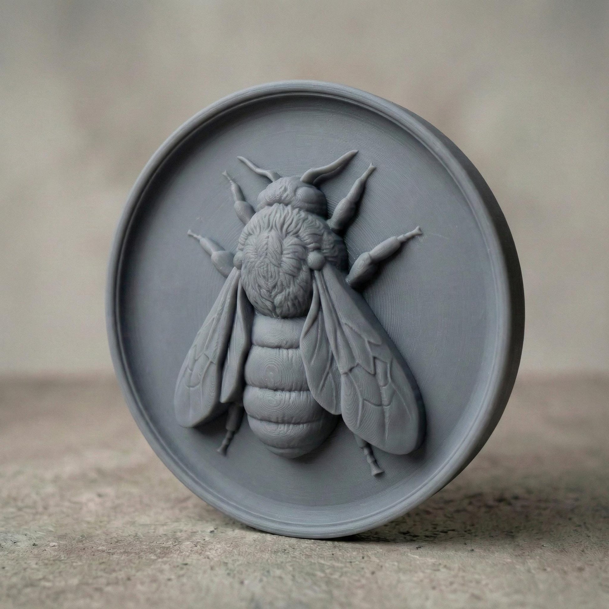 Round bas-relief featuring a realistic honey bee with detailed wings, textured thorax, and segmented abdomen carved in deep relief. The bee is centered on a circular wood panel with natural grain patterns, symbolizing spring renewal, pollination, and growth. Strong shadow lines and layered carving add depth and dimension, making this design ideal for CNC carving, 3D printing, and spring farmhouse wall decor.