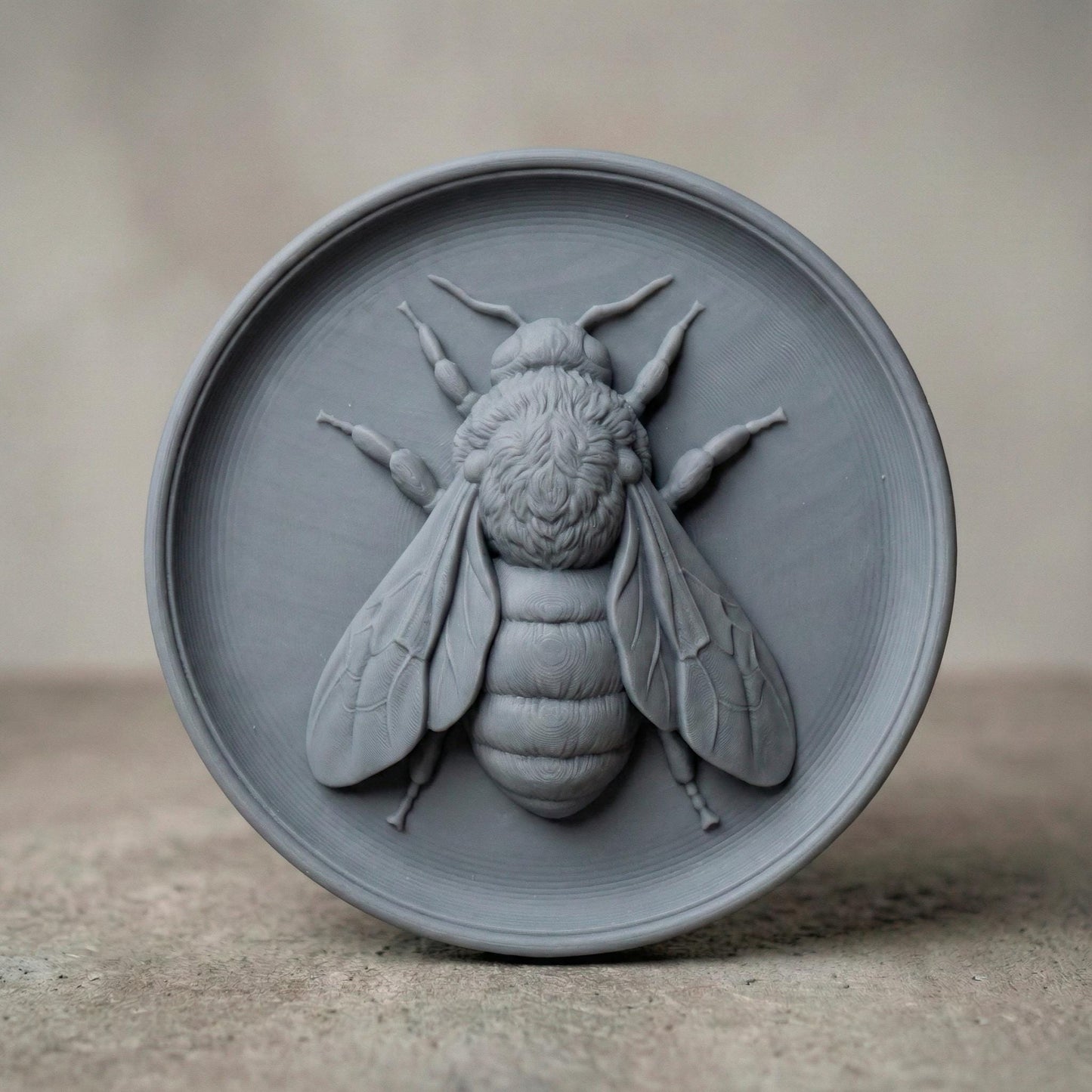 Round bas-relief featuring a realistic honey bee with detailed wings, textured thorax, and segmented abdomen carved in deep relief. The bee is centered on a circular wood panel with natural grain patterns, symbolizing spring renewal, pollination, and growth. Strong shadow lines and layered carving add depth and dimension, making this design ideal for CNC carving, 3D printing, and spring farmhouse wall decor.