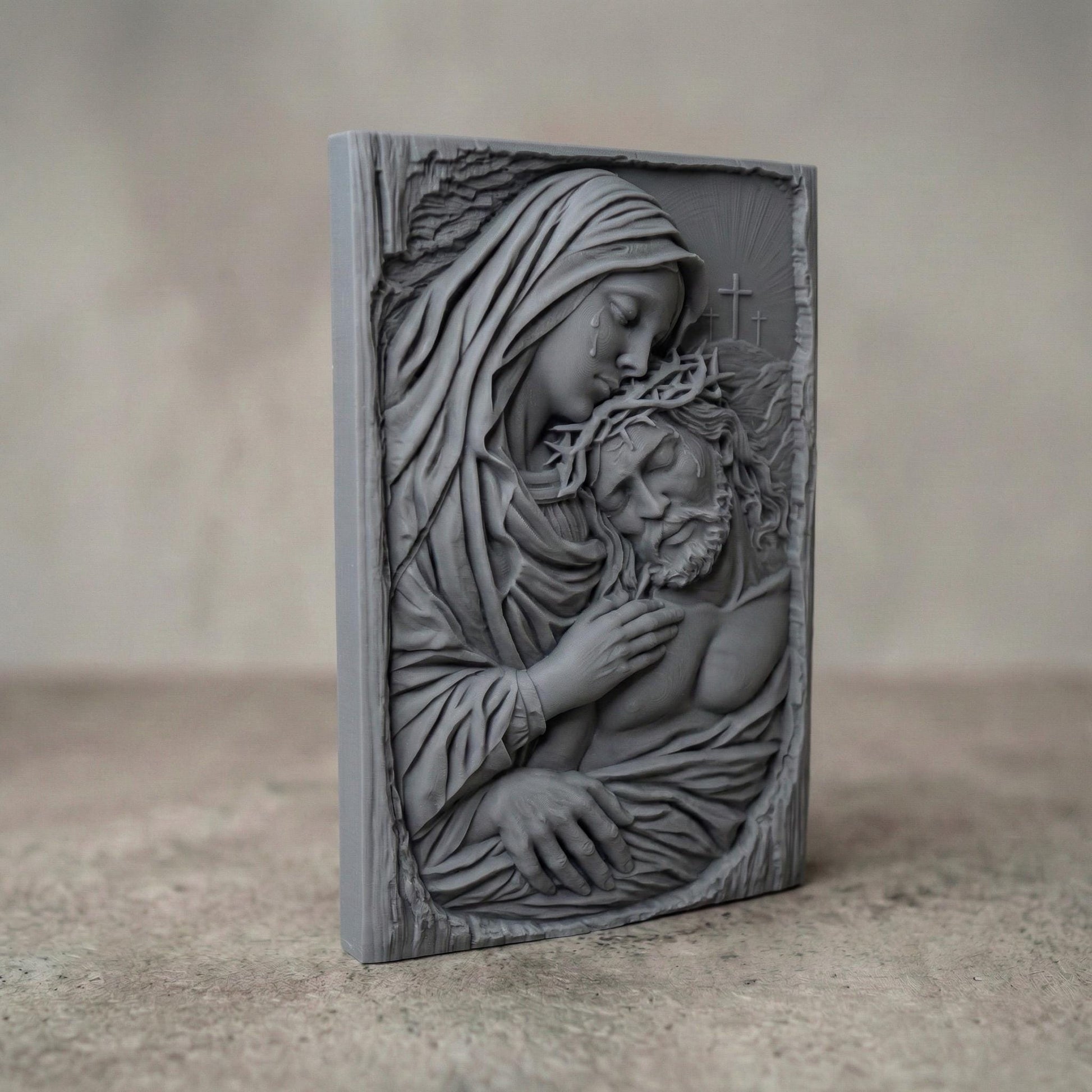 Highly detailed bas-relief sculpture of the Pietà showing the Virgin Mary gently holding the lifeless body of Jesus Christ after the crucifixion. Mary’s head rests tenderly against Jesus while tears fall from her face. Jesus wears a crown of thorns and appears peaceful. Three crosses rise in the background beneath radiant light, symbolizing Calvary. The composition features flowing robes, expressive anatomy, and deep relief ideal for CNC carving or 3D printing.