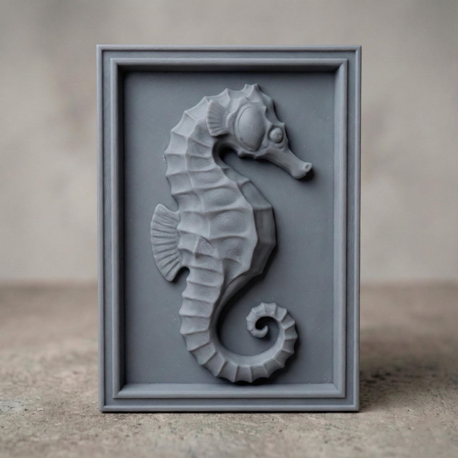 Detailed bas-relief seahorse carving mounted inside a rectangular wooden frame, featuring layered scales, curved tail, and textured dorsal ridges. The marine creature is sculpted in a relief style suitable for CNC carving or 3D printing, creating elegant coastal wall decor inspired by ocean life and nautical themes.