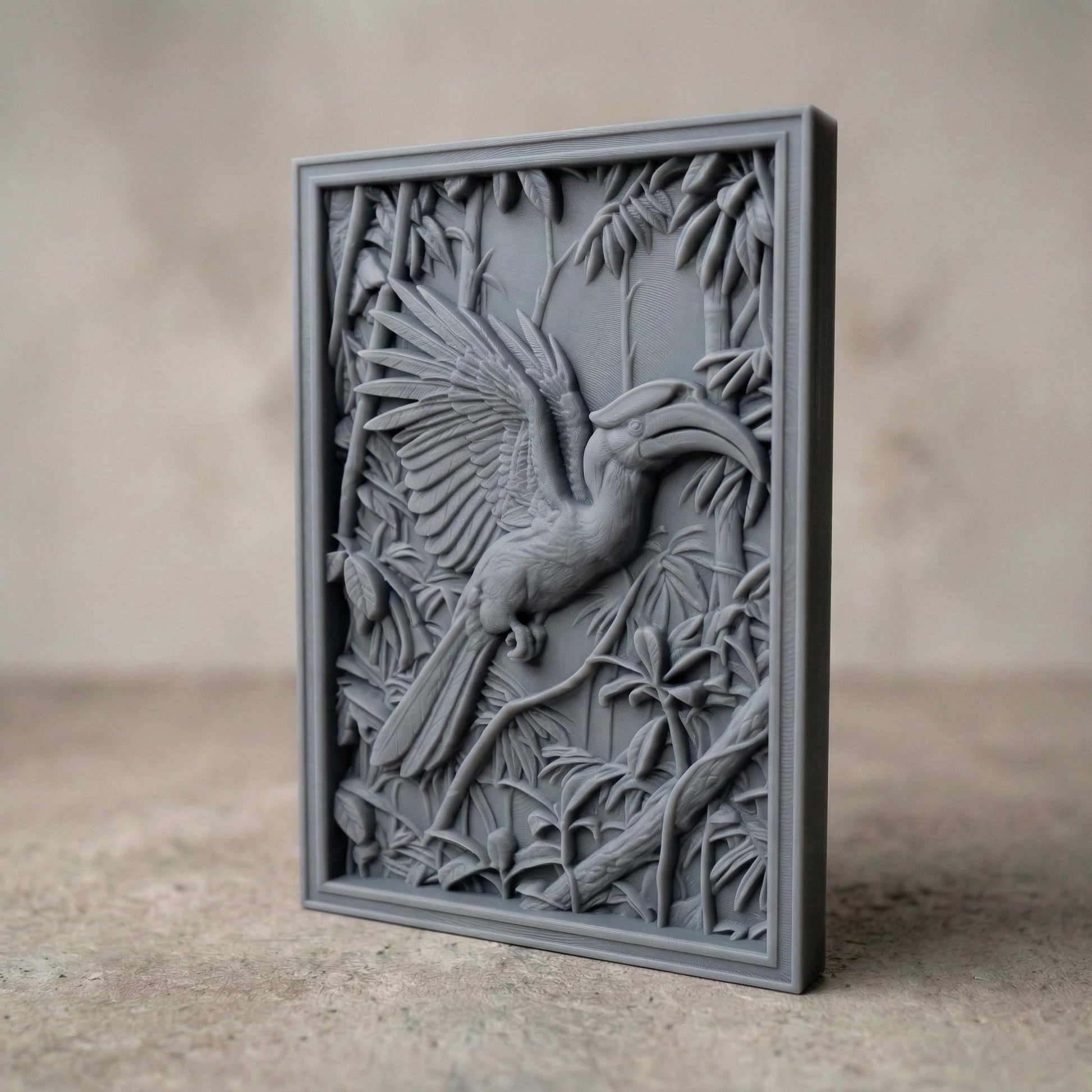 Highly detailed bas-relief carving of a hornbill bird with wide spread wings perched among dense tropical leaves and branches. The bird’s long curved beak and layered feathers are sculpted in deep relief, surrounded by jungle foliage that creates a rich wildlife scene suitable for CNC carving, 3D printing, or decorative wall art.