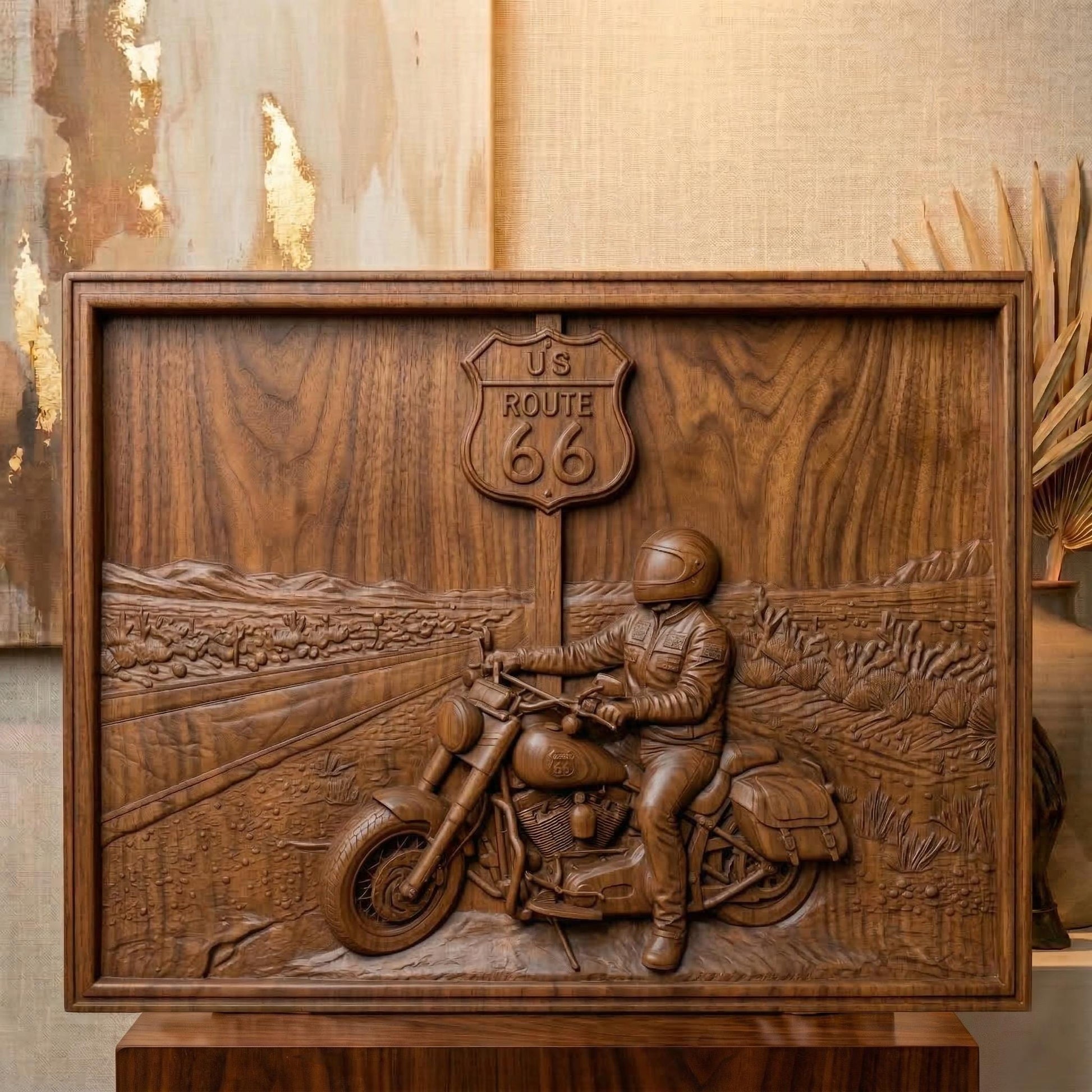 Detailed bas-relief scene of a motorcycle rider parked beside a US Route 66 road sign in a desert highway landscape. The rider wears a helmet and leather riding gear while sitting on a classic touring motorcycle with saddlebags. The background shows an open road stretching through desert terrain with cacti and distant mountains, symbolizing freedom, adventure, and the iconic American road trip culture.