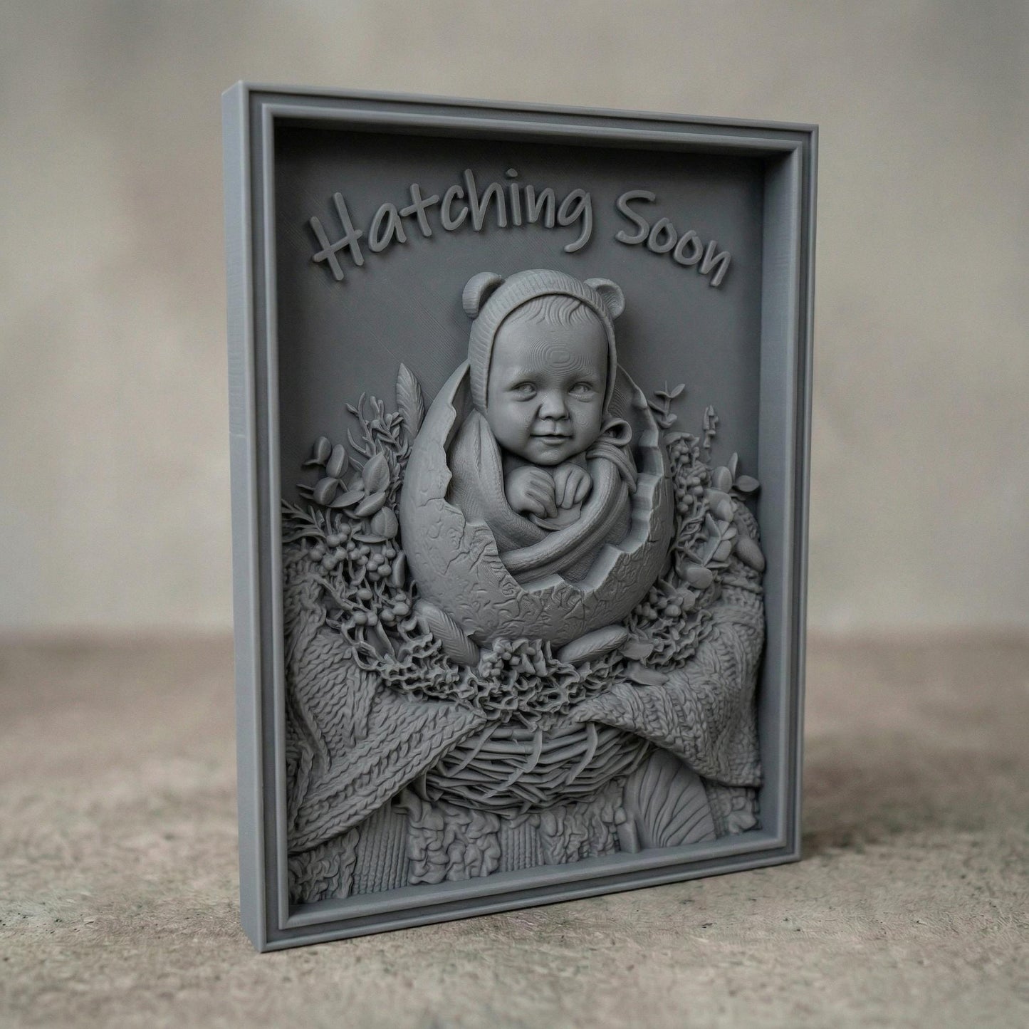 Highly detailed bas-relief carving of a smiling baby emerging from a cracked egg, surrounded by a woven nest and delicate foliage. The phrase “Hatching Soon” arches above, symbolizing anticipation and new life. Soft textures and layered wood grain create a warm, nurturing scene ideal for nursery decor or pregnancy announcements.