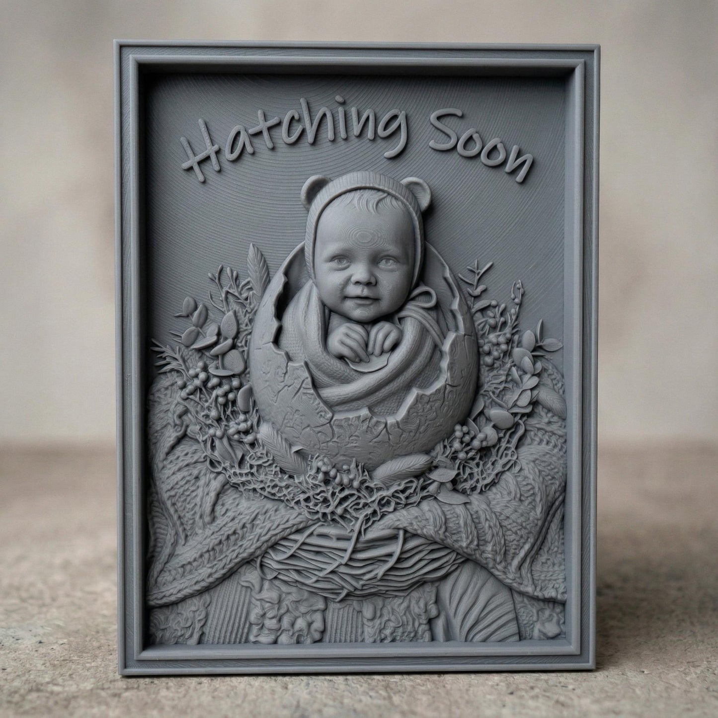 Highly detailed bas-relief carving of a smiling baby emerging from a cracked egg, surrounded by a woven nest and delicate foliage. The phrase “Hatching Soon” arches above, symbolizing anticipation and new life. Soft textures and layered wood grain create a warm, nurturing scene ideal for nursery decor or pregnancy announcements.
