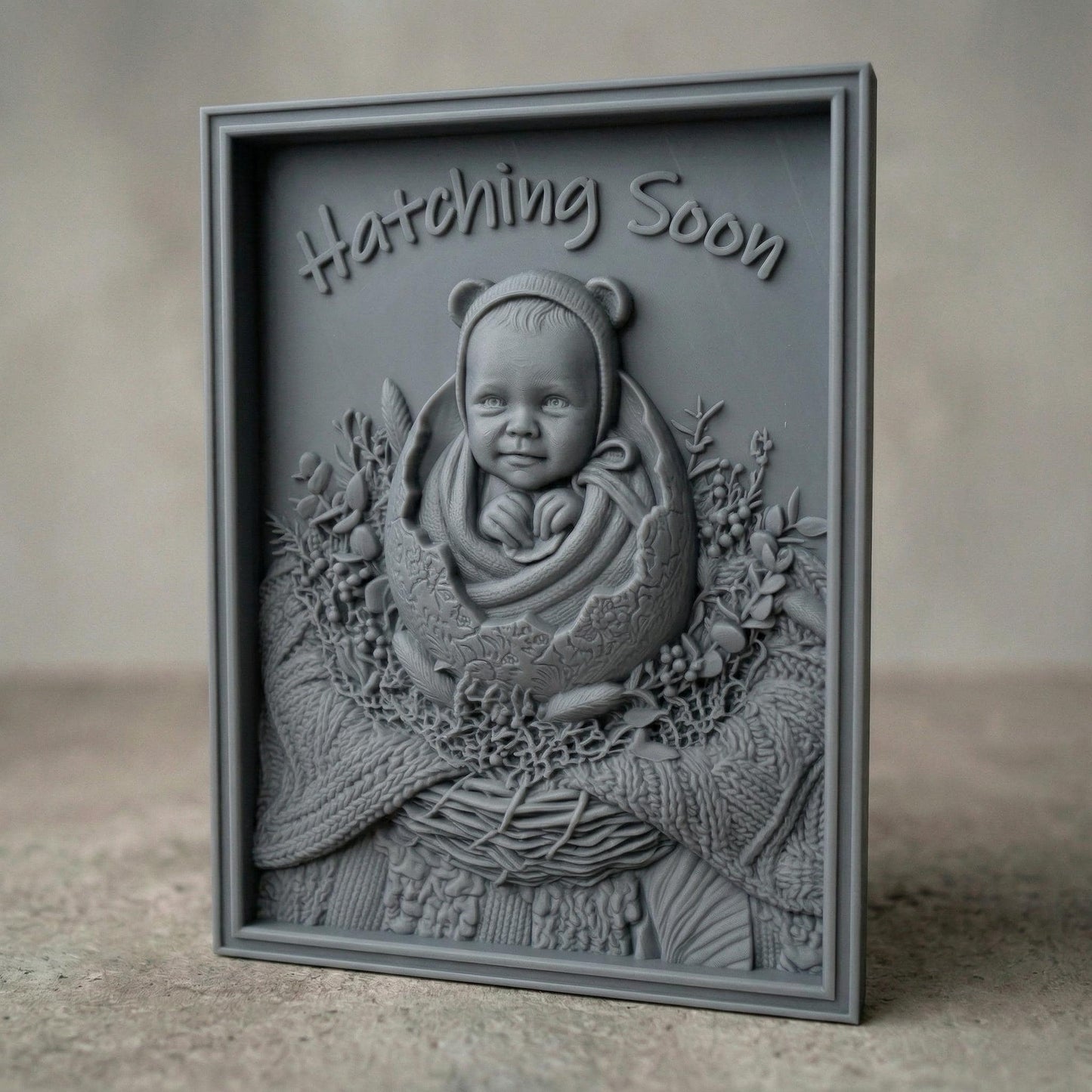 Highly detailed bas-relief carving of a smiling baby emerging from a cracked egg, surrounded by a woven nest and delicate foliage. The phrase “Hatching Soon” arches above, symbolizing anticipation and new life. Soft textures and layered wood grain create a warm, nurturing scene ideal for nursery decor or pregnancy announcements.