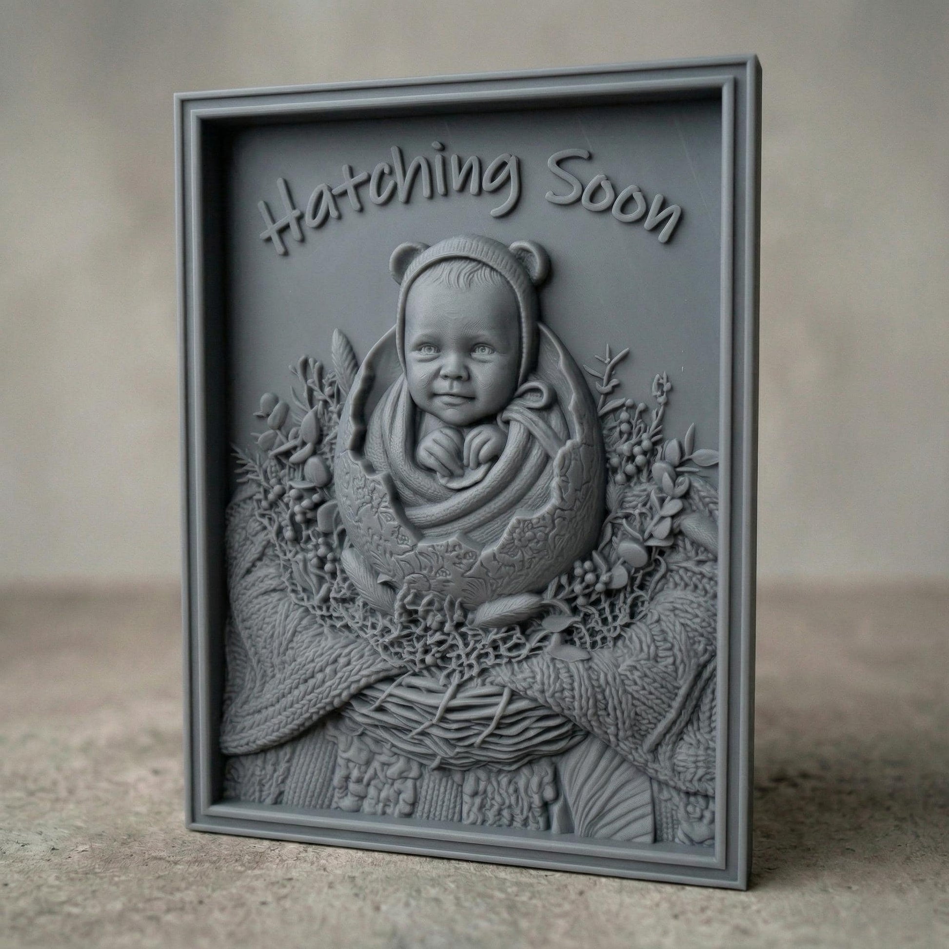 Highly detailed bas-relief carving of a smiling baby emerging from a cracked egg, surrounded by a woven nest and delicate foliage. The phrase “Hatching Soon” arches above, symbolizing anticipation and new life. Soft textures and layered wood grain create a warm, nurturing scene ideal for nursery decor or pregnancy announcements.