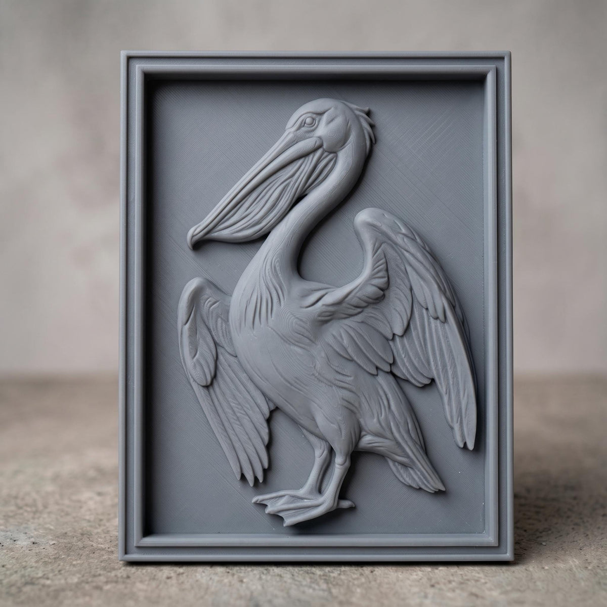 Detailed 3D bas-relief of a pelican standing with wings partly spread, long hooked bill and pouched throat, feather detail across the wings and breast. Carved in rich walnut wood grain and set within a raised rectangular frame border. Designed for CNC relief carving, wood routing, resin casting, and 3D printing as coastal wall decor.