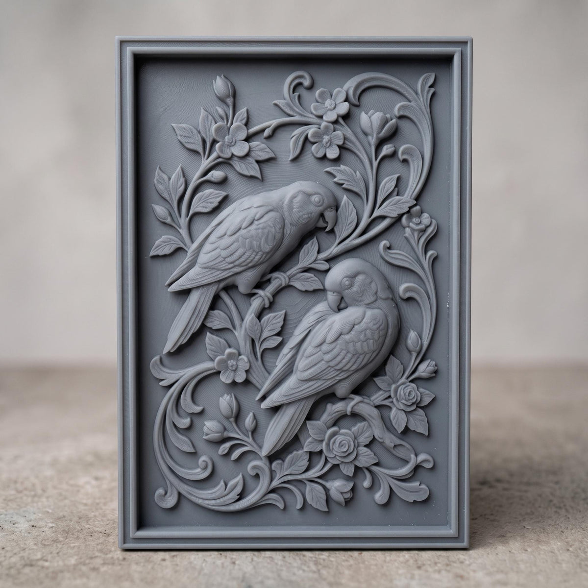 3D bas-relief of two parrots perched on a flowering branch, one above the other with heads turned and long tails sweeping down. Roses, blossoms, buds and acanthus scrollwork fill the panel around them. Set within a rectangular raised molded frame with fine feather and petal detail. Designed for CNC relief carving, wood routing, resin casting, and 3D printing as botanical wall decor.