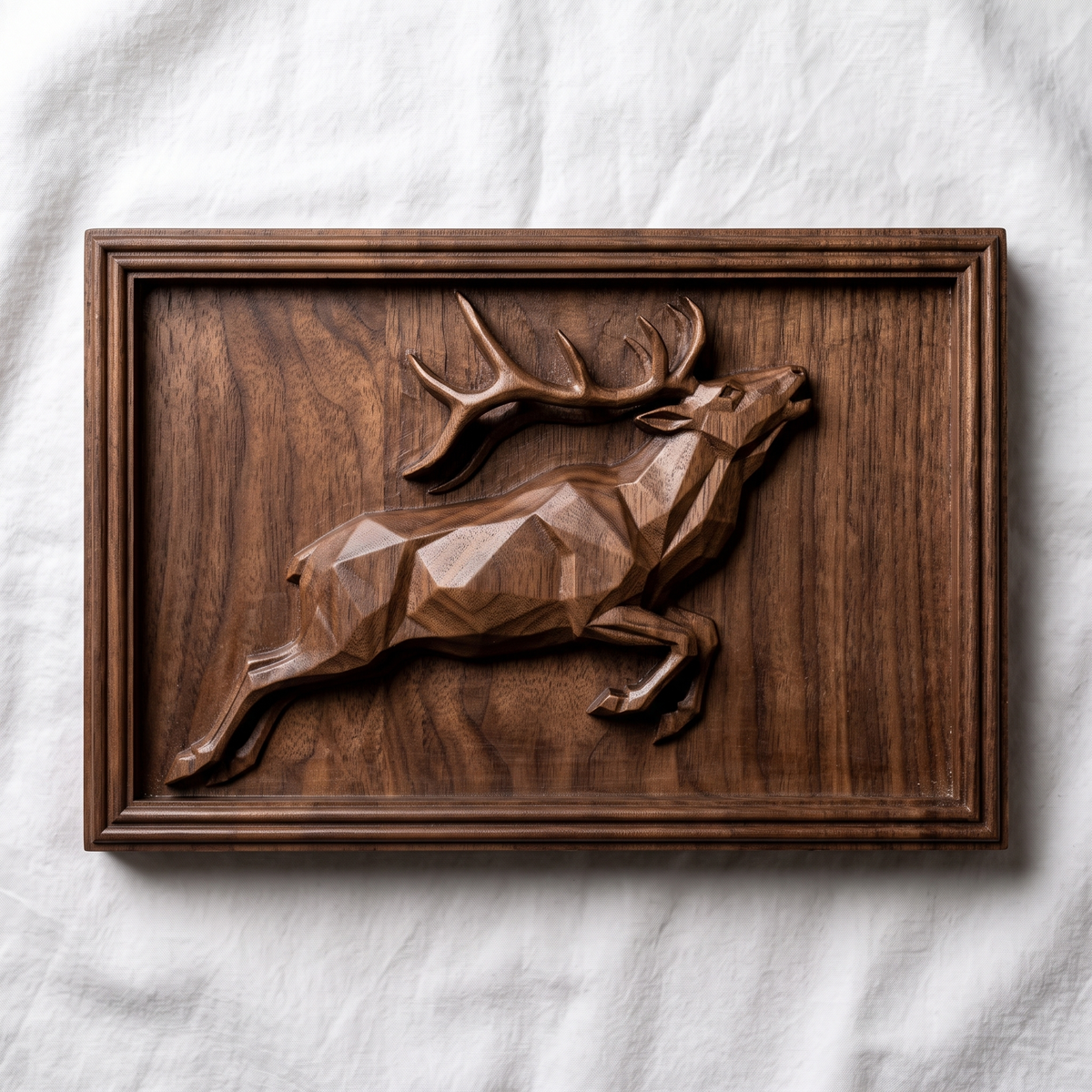 Detailed 3D bas-relief of a low poly geometric bull elk leaping with head raised and large antlers, faceted angular body and raised hooves, set inside a stepped molded rectangular frame. Shown in carved walnut wood and grey resin. Designed for CNC relief carving, woodworking and 3D printing as modern geometric wildlife wall decor.