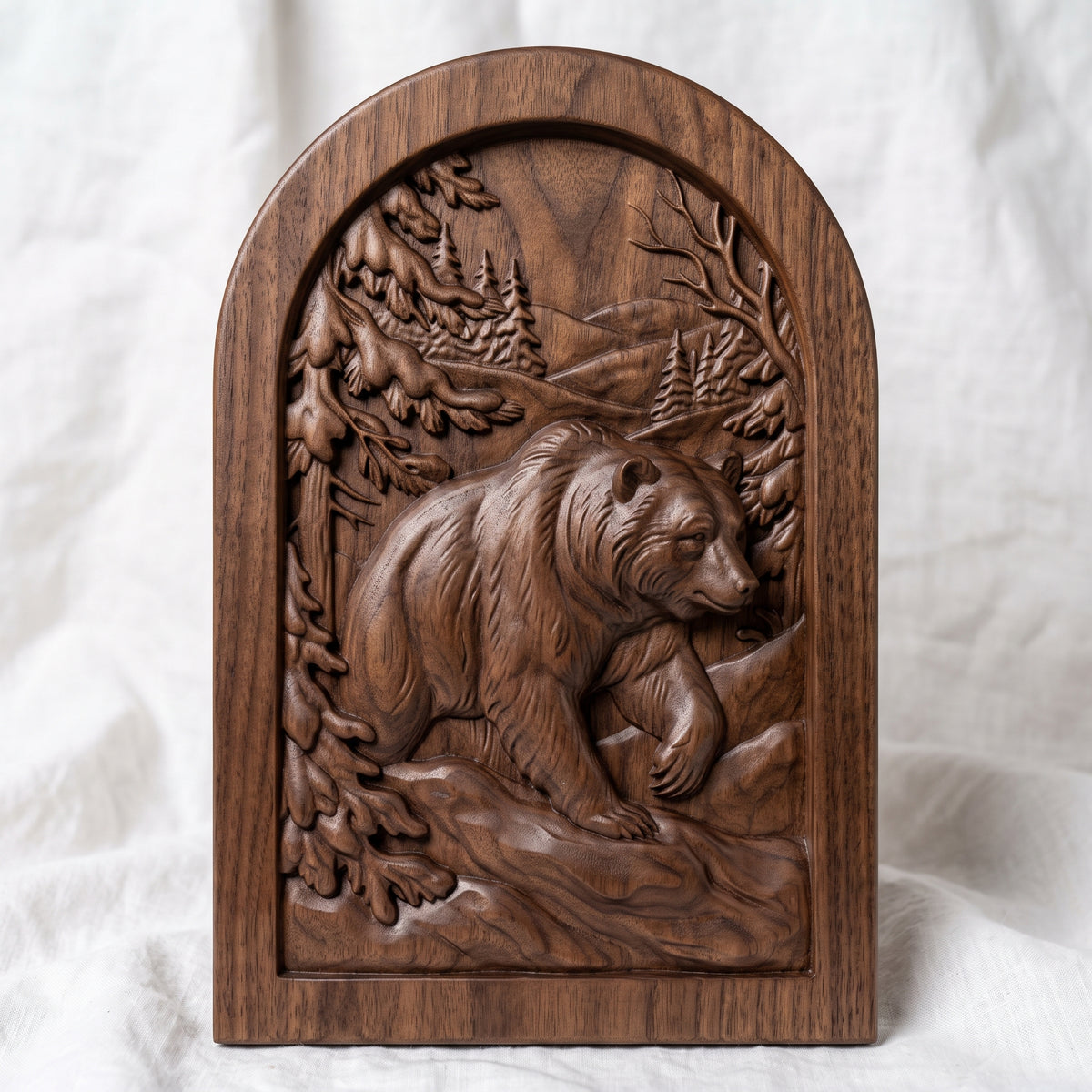 Detailed 3D bas-relief of a brown bear walking through a snowy winter forest, front paw raised, with snow-laden pine branches, bare winter branches, distant fir trees and rolling hills. Set in a recessed arched panel with a stepped molded frame. Fine fur and snow texture. Designed for CNC relief carving, woodworking and 3D printing as rustic cabin wall decor.