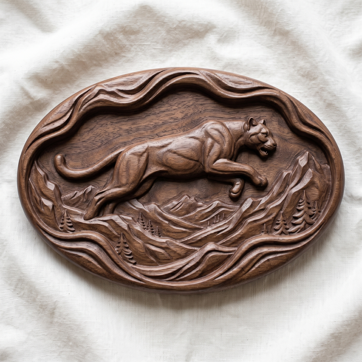 Leaping mountain lion carved in dark walnut wood on an oval wavy slab with flowing mountain ridges and pine trees, shown as a workshop mockup and a grey resin render. Digital STL relief file for CNC routers and 3D printers, ideal for wildlife wall art, panels and woodworking projects.