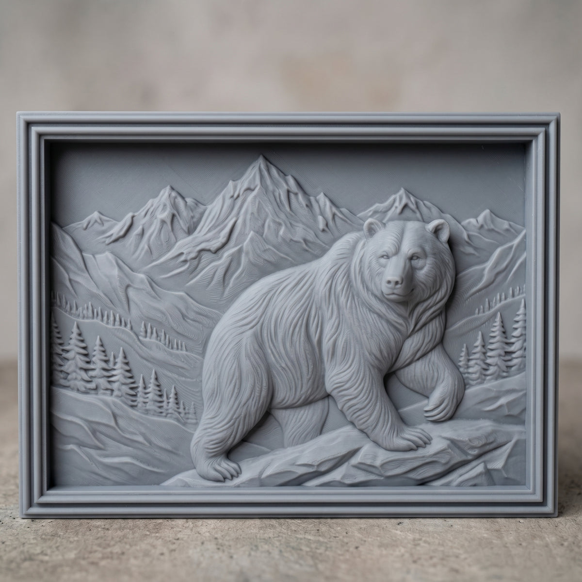 Detailed 3D bas-relief of a grizzly bear walking across rocky ground in front of snow-capped mountain peaks, with pine forest and alpine valleys behind. Framed by a rectangular stepped molded border around a recessed panel. Shown in carved walnut wood and grey resin. Designed for CNC relief carving, woodworking and 3D printing as rustic cabin and wildlife wall decor.