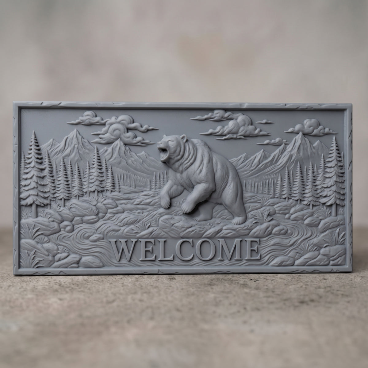 Detailed 3D bas-relief of a roaring grizzly bear standing on its hind legs in a mountain valley, with WELCOME lettering carved below. Pine forest, rocky stream, rugged peaks and billowing clouds fill the scene on a rectangular slab with a rough stone-style edge. Fine fur texture. Designed for CNC relief carving, woodworking and 3D printing as rustic cabin and porch wall decor.