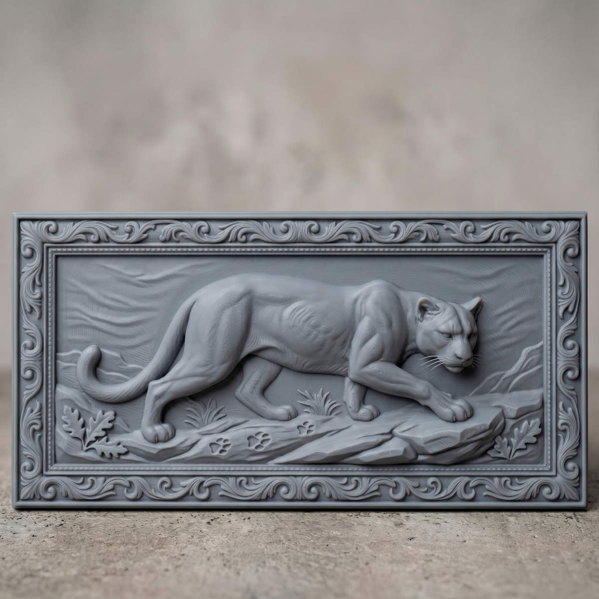 Prowling mountain lion carved in dark walnut wood inside an ornate scrollwork rectangular frame with oak leaves and rocky ledge, shown as a workshop mockup and a grey resin render. Digital STL relief file for CNC routers and 3D printers, ideal for wildlife wall art, panels and woodworking projects.
