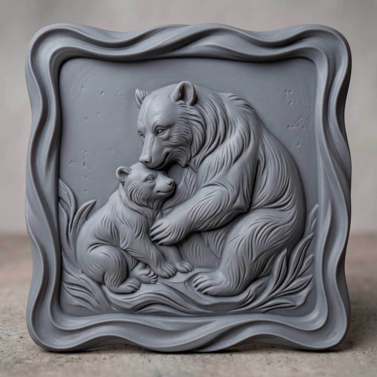 Detailed 3D bas-relief of a mama bear hugging and nuzzling her cub on grassy ground, with fine fur texture and wild grass blades. Framed by a thick raised wavy cloud-shaped border around a recessed square panel. Shown in carved walnut wood and grey resin. Designed for CNC relief carving, woodworking and 3D printing as nursery, cabin and wildlife wall decor.