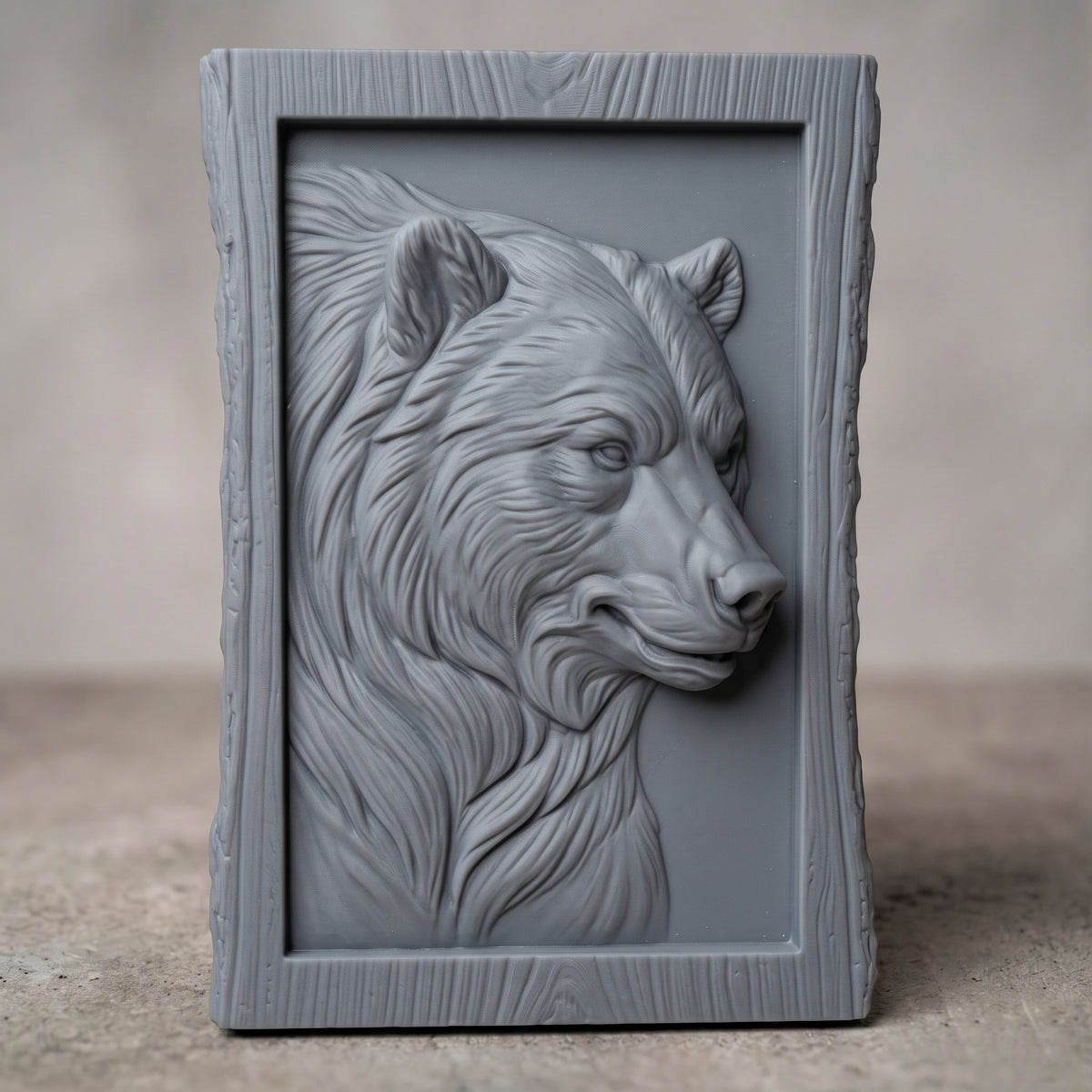 Detailed 3D bas-relief of a bear head in side profile with thick flowing fur, alert eyes and rounded ears, set inside a recessed panel. Framed by a rustic live edge wood border with natural bark texture and a raised inner rim. Shown in carved walnut wood and grey resin. Designed for CNC relief carving, woodworking and 3D printing as rustic cabin wildlife wall decor.